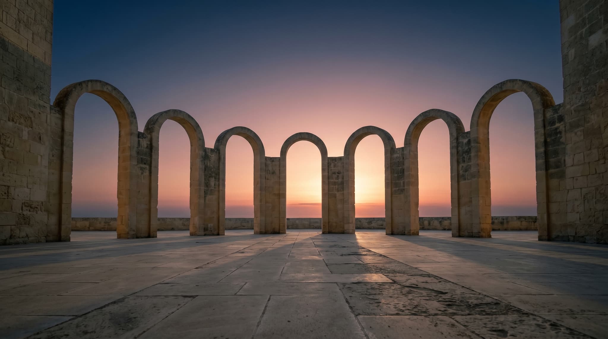 A still architectural courtyard at dawn — eight stone arches arranged in a wide arc, soft warm light breaking from behind the central arch